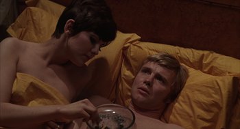 Movie still from “Midnight Cowboy” (1969), directed by John Schlesinger – A man and a woman eating food in bed; Medium shot, Overhead angle