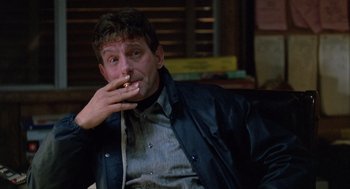 Movie still from “Midnight Run” (1988), directed by Martin Brest – A man smoking a cigarette while wearing a jacket; Close Up shot, Low angle