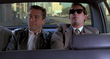 Movie still from “Midnight Run” (1988), directed by Martin Brest – Two men sitting in the back seat of a car; Medium shot, Low angle