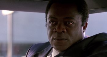Movie still from “Midnight Run” (1988), directed by Martin Brest – A person in a car looking at the camera; Close Up shot, Low angle