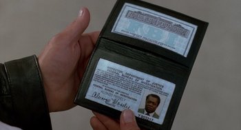Movie still from “Midnight Run” (1988), directed by Martin Brest – A person holding a passport in their hand; Extreme Close Up shot, High angle