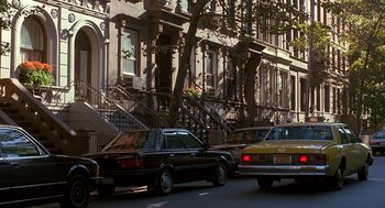 Movie still from “Midnight Run” (1988), directed by Martin Brest – Cars parked on the side of the street in front of a building; Extreme Wide shot, Low angle