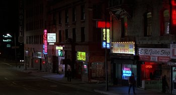 Movie still from “Midnight Run” (1988), directed by Martin Brest – Neon signs lit up on the side of a building; Extreme Wide shot, High angle