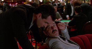 Movie still from “Midnight Run” (1988), directed by Martin Brest – Two men in suits are playing poker in a casino; Medium shot, Over the shoulder angle