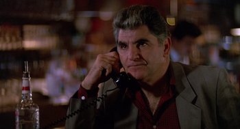 Movie still from “Midnight Run” (1988), directed by Martin Brest – An older man talking on a phone while wearing a jacket; Close Up shot, Low angle