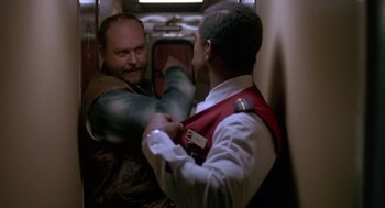 Movie still from “Midnight Run” (1988), directed by Martin Brest – Two men are fighting in a train car; Medium shot, Low angle