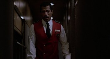 Movie still from “Midnight Run” (1988), directed by Martin Brest – A man wearing a red vest and a black tie; Medium shot, Low angle