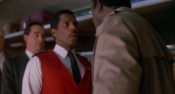 Movie still from “Midnight Run” (1988), directed by Martin Brest – A man in a red vest is talking to another man in a black tie; Close Up shot, Low angle