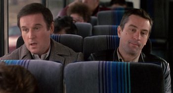 Movie still from “Midnight Run” (1988), directed by Martin Brest – Two men sitting on a train looking out the window; Close Up shot, High angle