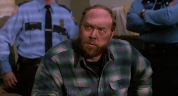 Movie still from “Midnight Run” (1988), directed by Martin Brest – A man with a beard and a plaid shirt; Close Up shot, Over the shoulder angle