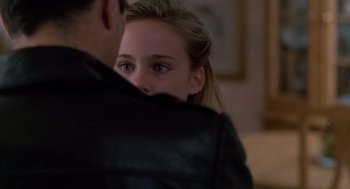 Movie still from “Midnight Run” (1988), directed by Martin Brest – A young girl is hugging a man in a leather jacket; Close Up shot, Over the shoulder angle