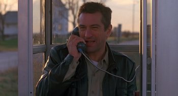 Movie still from “Midnight Run” (1988), directed by Martin Brest – A man talking on a phone while standing in front of a window; Close Up shot, Low angle