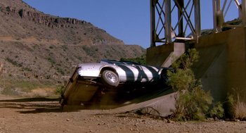 Movie still from “Midnight Run” (1988), directed by Martin Brest – A car that has fallen off of a bridge; Wide shot, High angle