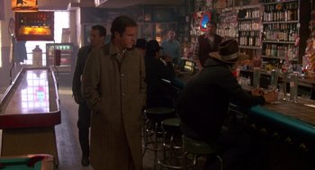 Movie still from “Midnight Run” (1988), directed by Martin Brest – A group of people standing around a bar; Wide shot, Over the shoulder angle