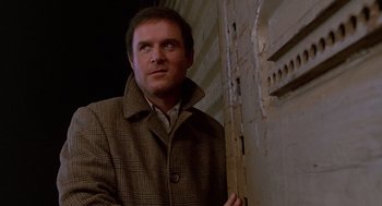 Movie still from “Midnight Run” (1988), directed by Martin Brest – A man standing next to a wall looking up; Close Up shot, Low angle