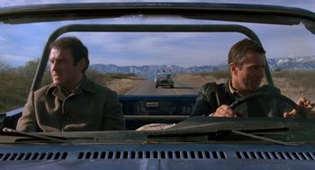 Movie still from “Midnight Run” (1988), directed by Martin Brest – Two men in the back of a truck driving down a road; Medium shot, Low angle