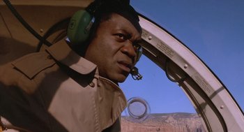 Movie still from “Midnight Run” (1988), directed by Martin Brest – A man in a helicopter cockpit looking into the sky; Close Up shot, Low angle