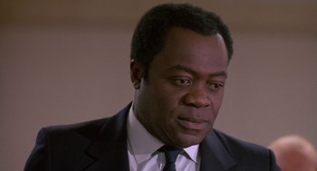 Movie still from “Midnight Run” (1988), directed by Martin Brest – A man in a suit and tie looking to his left; Close Up shot, Low angle