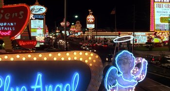 Movie still from “Midnight Run” (1988), directed by Martin Brest – A neon sign that says " angel " on the side of the road; Wide shot, High angle