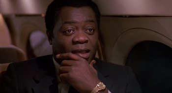 Movie still from “Midnight Run” (1988), directed by Martin Brest – A man in a suit sitting in a car; Close Up shot, Low angle