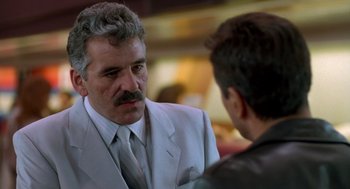 Movie still from “Midnight Run” (1988), directed by Martin Brest – A man wearing a suit and tie talking to another man wearing a suit and tie; Close Up shot, Over the shoulder angle
