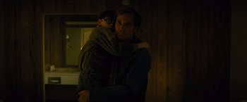 Movie still from “Midnight Special” (2016), directed by Jeff Nichols – A man holding a child in his arms in the dark; Medium shot, Over the shoulder angle