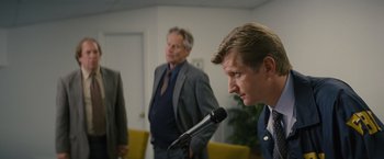 Movie still from “Midnight Special” (2016), directed by Jeff Nichols – A man in a suit and tie standing next to another man in a suit; Medium shot, Over the shoulder angle