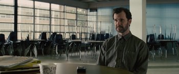 Movie still from “Midnight Special” (2016), directed by Jeff Nichols – A man sitting at a table in front of a window; Medium shot, Over the shoulder angle