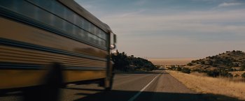 Movie still from “Midnight Special” (2016), directed by Jeff Nichols – A school bus driving down a road near the desert; Extreme Wide shot, High angle