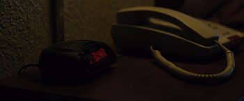 Movie still from “Midnight Special” (2016), directed by Jeff Nichols – An alarm clock sitting on top of a wooden table; Extreme Close Up shot, High angle