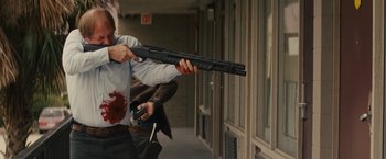 Movie still from “Midnight Special” (2016), directed by Jeff Nichols – A man with a gun in his hand and a gun in his other hand; Medium shot, Over the shoulder angle