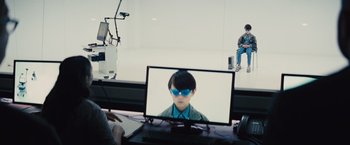 Movie still from “Midnight Special” (2016), directed by Jeff Nichols – A man wearing sunglasses is sitting in front of a computer screen; Wide shot, Over the shoulder angle