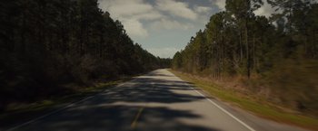 Movie still from “Midnight Special” (2016), directed by Jeff Nichols – A road that has some trees on the side of the road; Extreme Wide shot, High angle