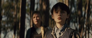 Movie still from “Midnight Special” (2016), directed by Jeff Nichols – A boy and a woman standing next to each other in front of a tree; Close Up shot, Low angle
