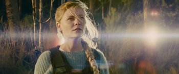 Movie still from “Midnight Special” (2016), directed by Jeff Nichols – A woman with long blonde plaits standing in a forest; Close Up shot, Low angle
