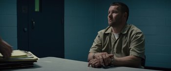 Movie still from “Midnight Special” (2016), directed by Jeff Nichols – A man sitting at a table in a jail cell; Medium shot, Over the shoulder angle