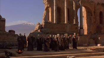 Movie still from “Mighty Aphrodite” (1995), directed by Woody Allen – A group of people standing next to each other on a street; Extreme Wide shot, Low angle
