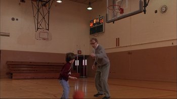Movie still from “Mighty Aphrodite” (1995), directed by Woody Allen – An older man and a young boy playing basketball; Wide shot, Low angle