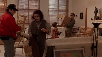 Movie still from “Mighty Aphrodite” (1995), directed by Woody Allen – A group of people in a living room with furniture; Wide shot, High angle