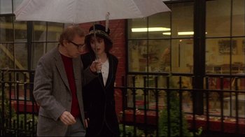 Movie still from “Mighty Aphrodite” (1995), directed by Woody Allen – A man and a woman walking under an umbrella in the rain; Medium shot, Low angle