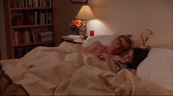 Movie still from “Mighty Aphrodite” (1995), directed by Woody Allen – A man and a woman laying in bed under a blanket; Medium shot, Overhead angle