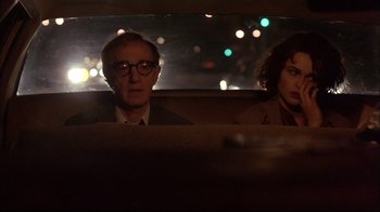 Movie still from “Mighty Aphrodite” (1995), directed by Woody Allen – A man and a woman sitting in the back of a car; Medium shot, Over the shoulder angle