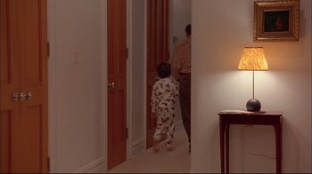 Movie still from “Mighty Aphrodite” (1995), directed by Woody Allen – A man and a child are walking through a hallway; Wide shot, High angle