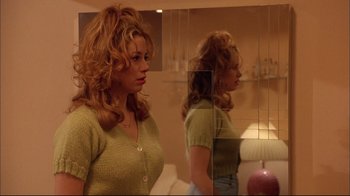 Movie still from “Mighty Aphrodite” (1995), directed by Woody Allen – A woman standing in front of a bathroom mirror; Medium shot, Low angle