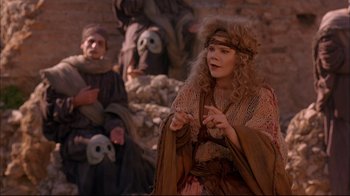Movie still from “Mighty Aphrodite” (1995), directed by Woody Allen – A woman dressed in medieval clothing talking to another person; Medium shot, Over the shoulder angle