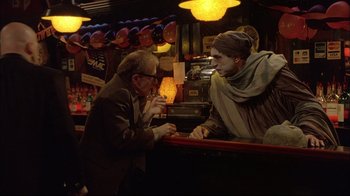 Movie still from “Mighty Aphrodite” (1995), directed by Woody Allen – A man and a woman sitting at a bar; Medium shot, Over the shoulder angle