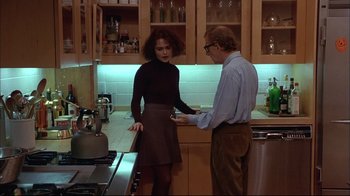 Movie still from “Mighty Aphrodite” (1995), directed by Woody Allen – A man and a woman standing in a kitchen talking; Medium shot, Over the shoulder angle