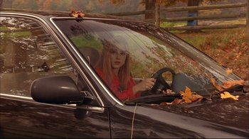 Movie still from “Mighty Aphrodite” (1995), directed by Woody Allen – A woman sitting in the driver's seat of a car; Medium shot, High angle