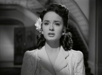 Movie still from “Mildred Pierce” (1945), directed by Michael Curtiz – A woman with a flower in her hair; Close Up shot, High angle