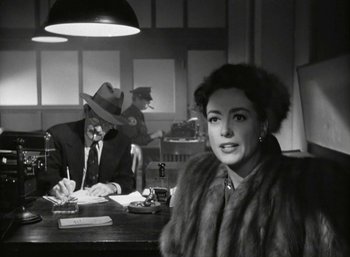 Movie still from “Mildred Pierce” (1945), directed by Michael Curtiz – An old photo of a man and a woman at a table; Medium shot, Over the shoulder angle